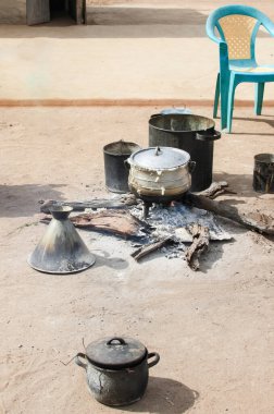 Köy avlusunda mısır lapası pişiriyorum. Afrika geleneklerine göre yemek ve çay pişirme süreci açık ateşte gerçekleşir.. 