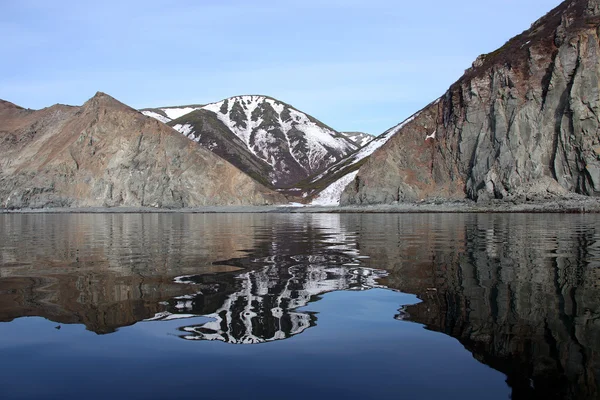 Reflektion av stranden i det klara blå vattnet i Ochotska havet — Stockfoto