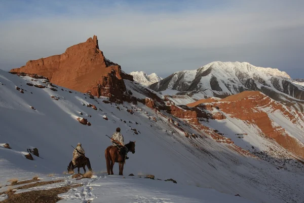 Jägare till häst på vintern i bergen av Tien Shan, Kirgizistan??? ?? ??????? ? ????? — Stockfoto