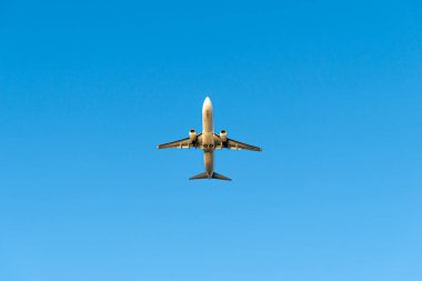 Uçan uçak, aşağıdan görünen mavi gökyüzü arka planda