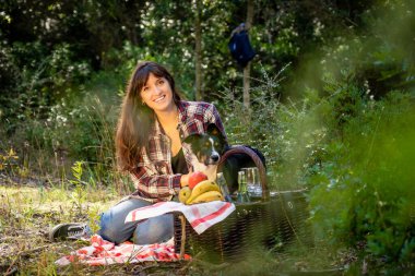 Sınır köpeği ile güzel genç bir kadın Akdeniz 'in doğal parkında piknik yapıyor, genç bir kadın kameraya mutlu bir şekilde gülümsüyor.