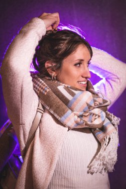 Güzel genç bir kadının portresi. Geceleri saçlarını tarıyor. Arka planda mor bir ışık var.