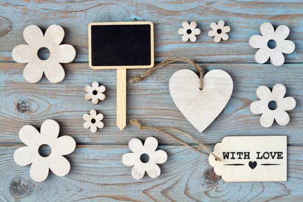 Blue grey old used beach Wooden background with wooden flowers decoration and with label and heart shape photo frame