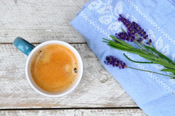 Blue coffee cup on a old white wooden shelves background with lavender flowers and kitchen towel and empty copy space. — Stock Photo, Image