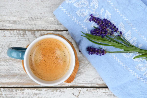 Blue coffee cup on a old white wooden shelves background with lavender flowers and kitchen towel and empty copy space. — Stock Photo, Image