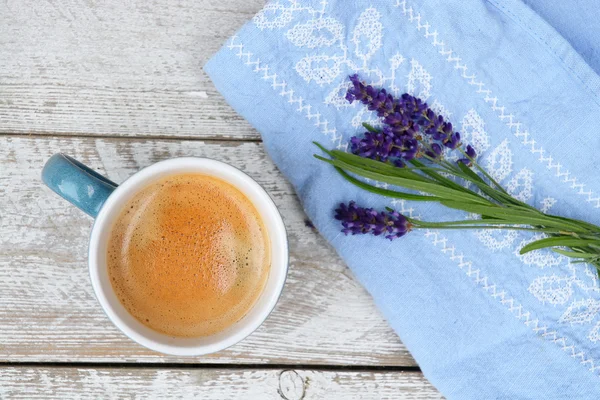 Blue coffee cup on a old white wooden shelves background with lavender flowers and kitchen towel and empty copy space. — Stock Photo, Image