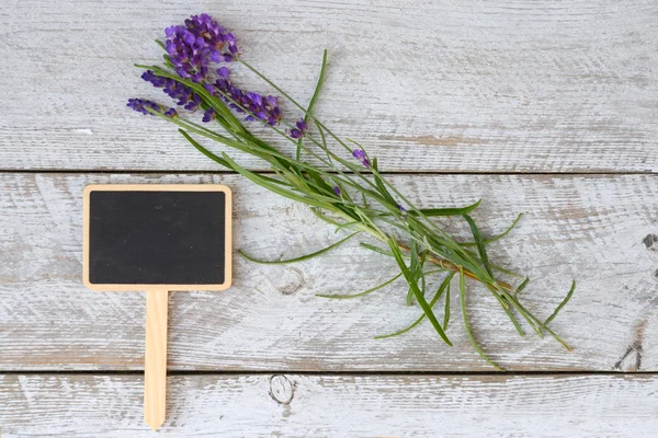 Branco cinza velho prateleiras de madeira fundo com placa de giz vazio e espaço de cópia e flores de lavanda decoração — Fotografia de Stock