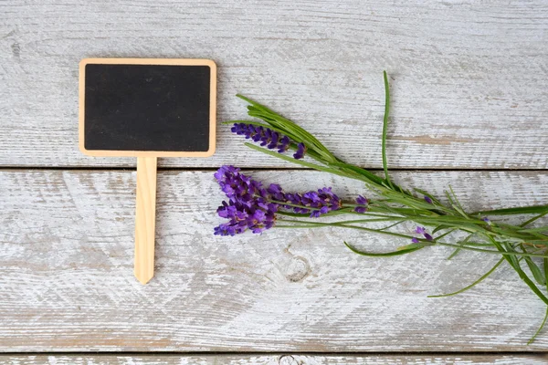 Branco cinza velho prateleiras de madeira fundo com placa de giz vazio e espaço de cópia e flores de lavanda decoração — Fotografia de Stock