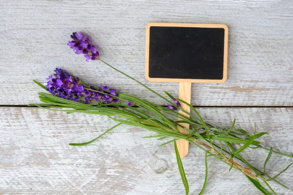 Branco cinza velho prateleiras de madeira fundo com placa de giz vazio e espaço de cópia e flores de lavanda decoração — Fotografia de Stock