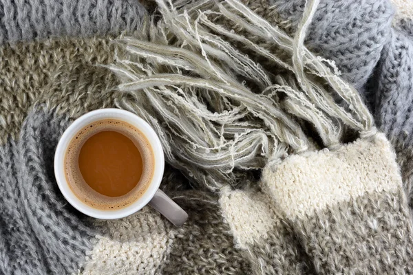 Cioccolata calda in tazza di caffè con una sciarpa grigia, avorio, ecru lavorata a maglia intorno e barretta di cioccolato — Foto Stock