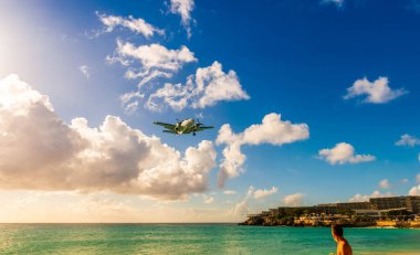 Landing of an airplane from Maho beach on the island of Saint Martin in the Caribbean clipart