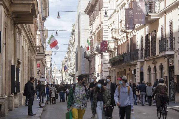 Roma, İtalya - 13 Mart 2021: Roma şehir merkezindeki Via del Corso ana alışveriş caddesinde toplanan insanlar, hükümet 15 Mart 'tan itibaren ülke genelindeki kısıtlamaları sıkılaştırmadan önce, 