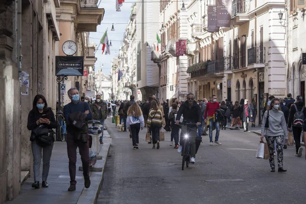 Roma, İtalya - 13 Mart 2021: Roma şehir merkezindeki Via del Corso ana alışveriş caddesinde toplanan insanlar, hükümet 15 Mart 'tan itibaren ülke genelindeki kısıtlamaları sıkılaştırmadan önce, 