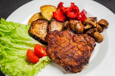 Izgara domuz eti, ızgara sebze, mantar, domates.