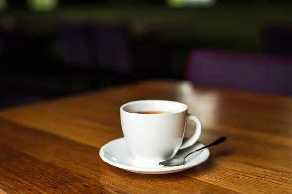 Uma Xícara Branca Café Preto Pires Brancos Colher Mesa Madeira — Fotografia de Stock