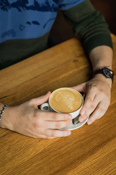 Mãos Masculinas Segurando Uma Xícara Café Cappuccino Mesa Madeira — Fotografia de Stock