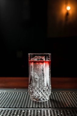 Barda buzlu, şeffaf katmanlı bir kokteyl.