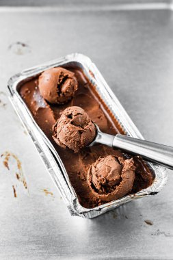 Bir kutu çikolatalı dondurma ve bir kepçe top.