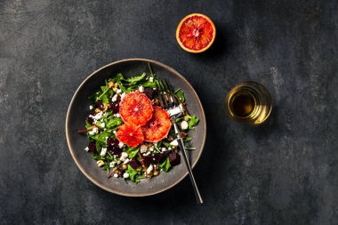 Roketli salata, pazı, pancar, feta veya brynza peyniri, ceviz ve kan portakalı. Bir bardak beyaz şarap. Üst görüntü fotoğrafı.