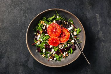 Roketli salata, pazı, pancar, feta veya brynza peyniri, ceviz ve kan portakalı. Üst görünüm yakın plan fotoğraf.