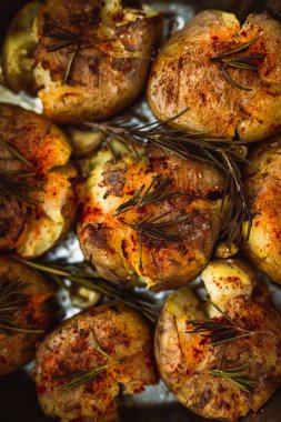 Biberiye ve baharatla pişirilmiş patatesler, dikey görüntüye yakın çekim.