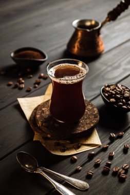 Cezve 'de kahve yapıyorum. Fasulye, kahve, kahve. Bir bardak kahve. Ahşap zemin.