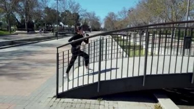 Köprüdeki parkta koşan bir genç. Yavaş çekim