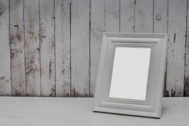 Fotoğrafsız beyaz ahşap fotoğraf çerçevesi. Tahta bir arka planda..