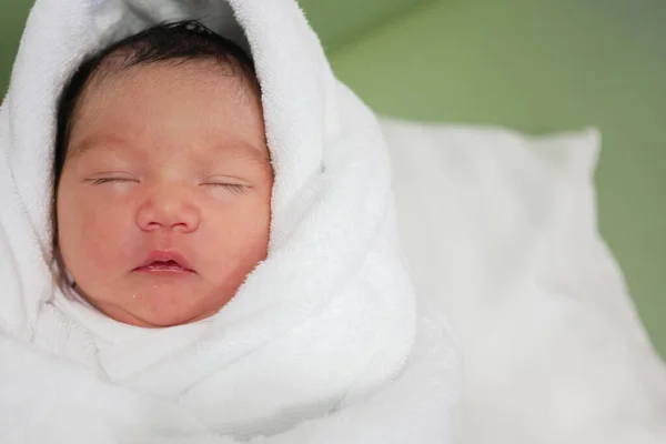 かわいいアジア系の新生児がベッドの上に横たわる白い布で彼の目を閉じました — ストック写真