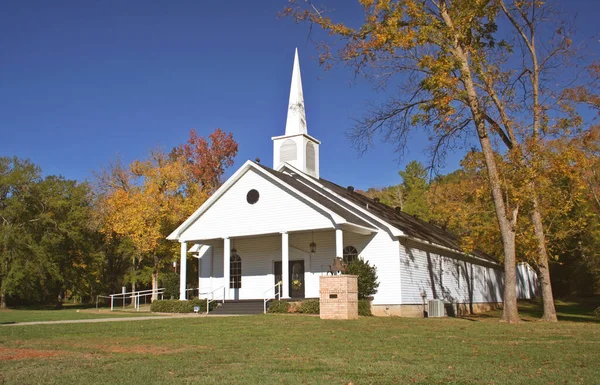 Rural Church in Autumn. White Church with golden leaves