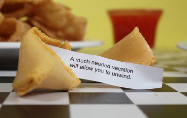 Fortune Cookie on table with Chinese Food in Background, A Much Needed Vacation Will allow you to unwind