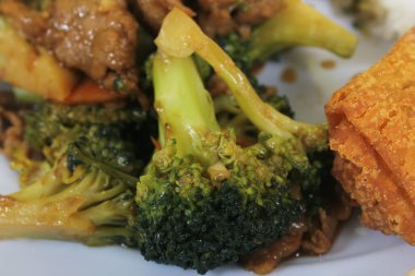 Beef Broccoli and Egg Roll on Plate at Chinese Restaurant