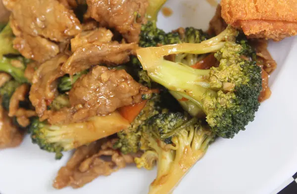 Beef Broccoli and Egg Roll on Plate at Chinese Restaurant