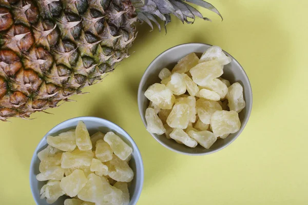 Fresh and Dried Organic Pineapple on yellow Background Closeup