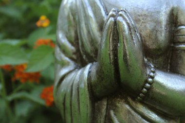 Arka planda yeşil bitkiler olan, Bahçedeki Buda Heykeli