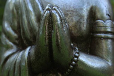 Arka planda yeşil bitkiler olan, Bahçedeki Buda Heykeli