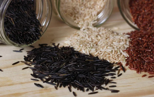 Kahverengi pirinç ve Himalaya kırmızısı ile Tahta Masa üzerinde Kara Yaban Pirinci