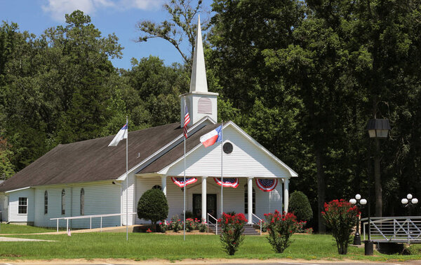 Маленькая белая церковь с флагами в сельской местности Техаса