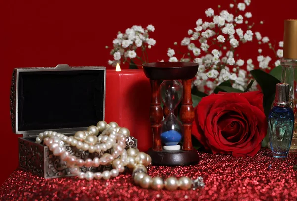 赤のキャンドルと赤のベルベットの背景にローズガラス — ストック写真
