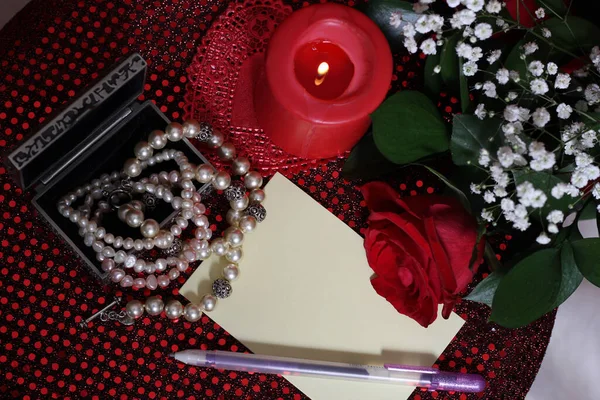 Rose and Candle With Pearls on Red Background
