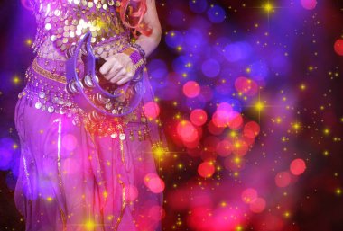 Göbek Dansçısı mor dans kostümü giyiyor. Renkli bokeh ile yakın plan.