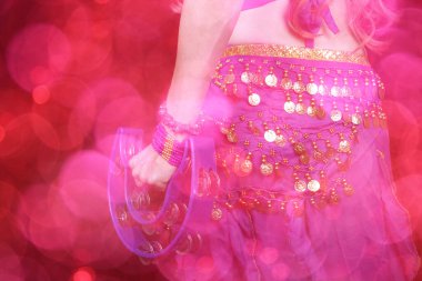 Göbek Dansçısı mor dans kostümü giyiyor. Renkli bokeh ile yakın plan.