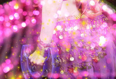 Göbek Dansçısı mor dans kostümü giyiyor. Renkli bokeh ile yakın plan.