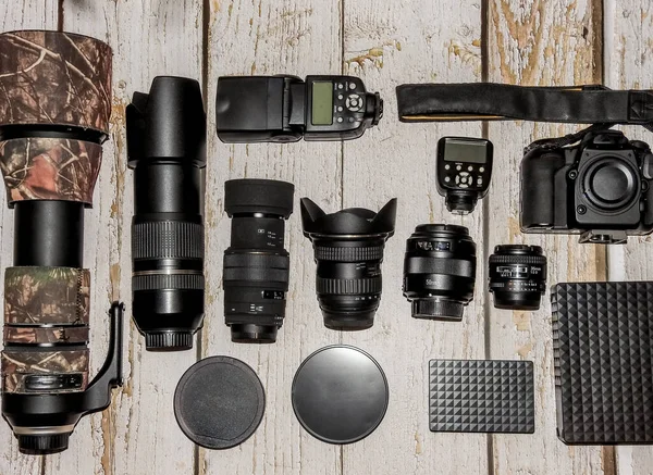 aerial view of professional photographic equipment with reflex camera, lenses, filters and flash