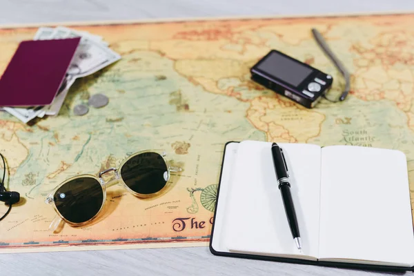 世界地図上の旅行準備アクセサリー カメラ パスポート サングラス ノートを取る 旅行準備の概念 — ストック写真