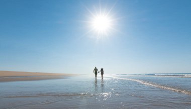 Yalnız bir sahilde el ele tutuşan balayı çifti. Yeni evliler yaz tatilinde dinleniyorlar. Seyahat ve aşk konsepti