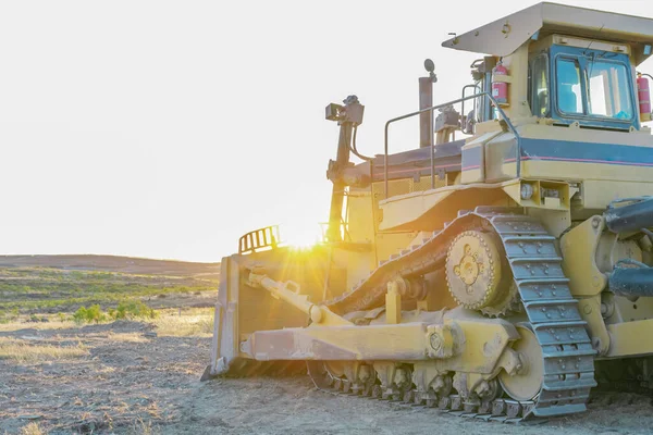 重い機械だ バックグラウンドで日没と建設現場で大型トラクターショベルブルドーザー — ストック写真