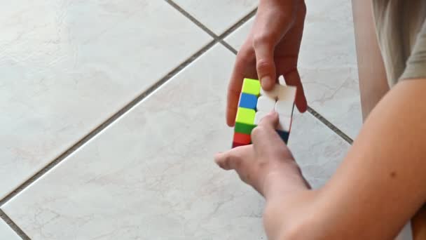 Närbild Händerna Unge Som Försöker Lösa Rubiks Kub Ovanifrån — Stockvideo