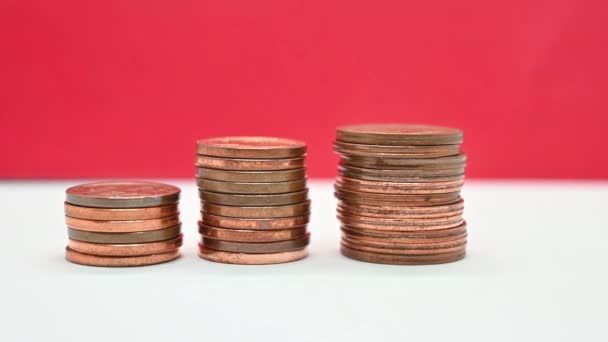 Monedas Bronce Apiladas Sobre Una Superficie Blanca Sobre Fondo Rojo — Vídeos de Stock