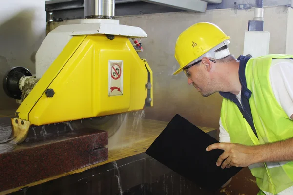 Övervaka medan maskinen skär marmor sten. — Stockfoto